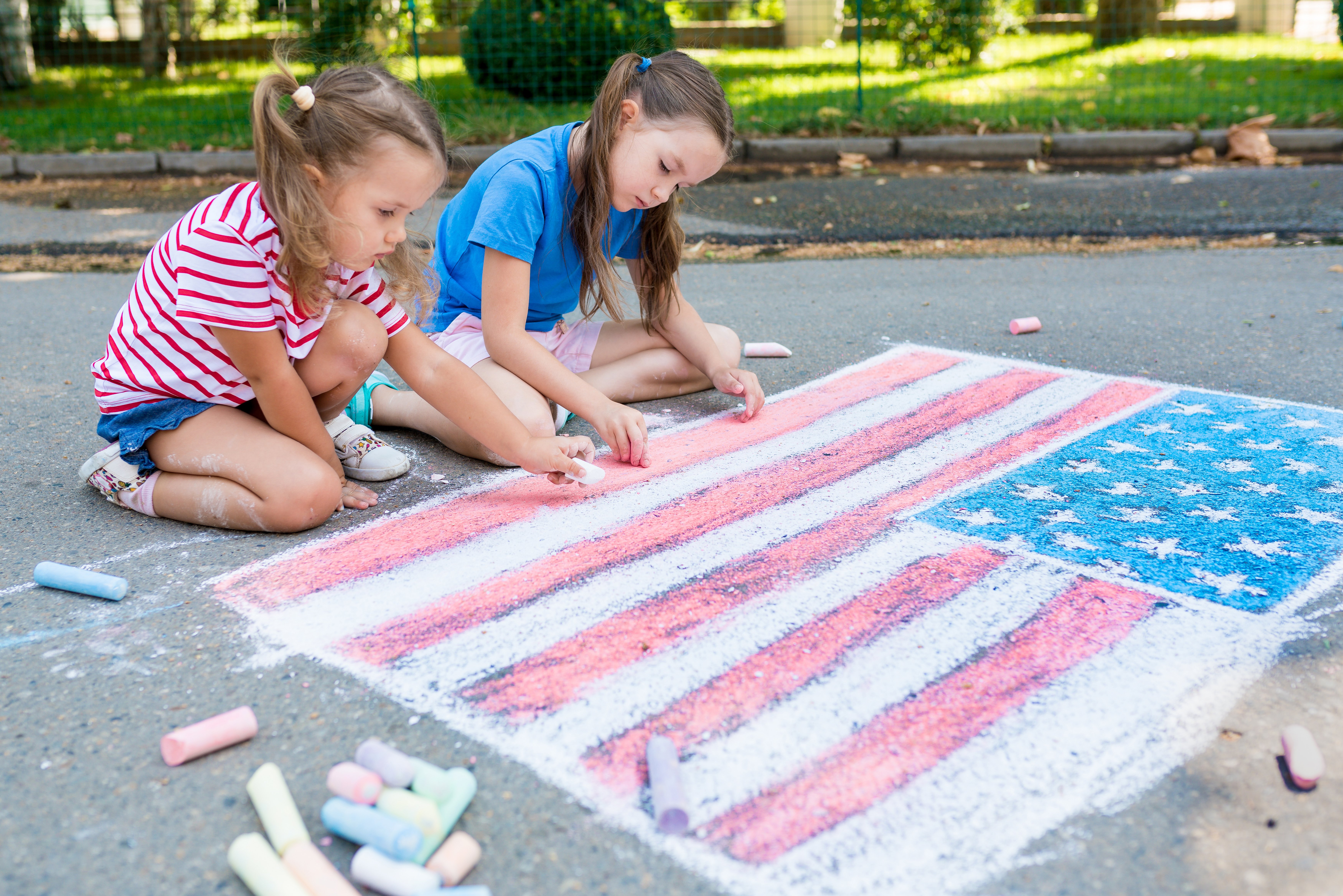 two girls sidewalk chalk american flag america