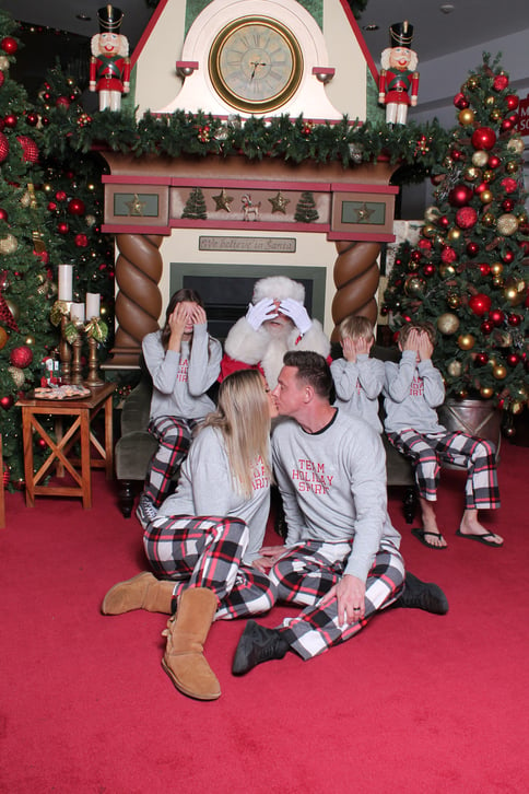 Couple kissing in front of santa