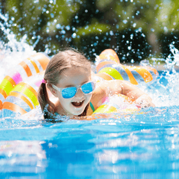 A girl swimming in the pool with goggles on.
