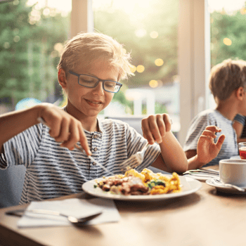A boy eating dinner.