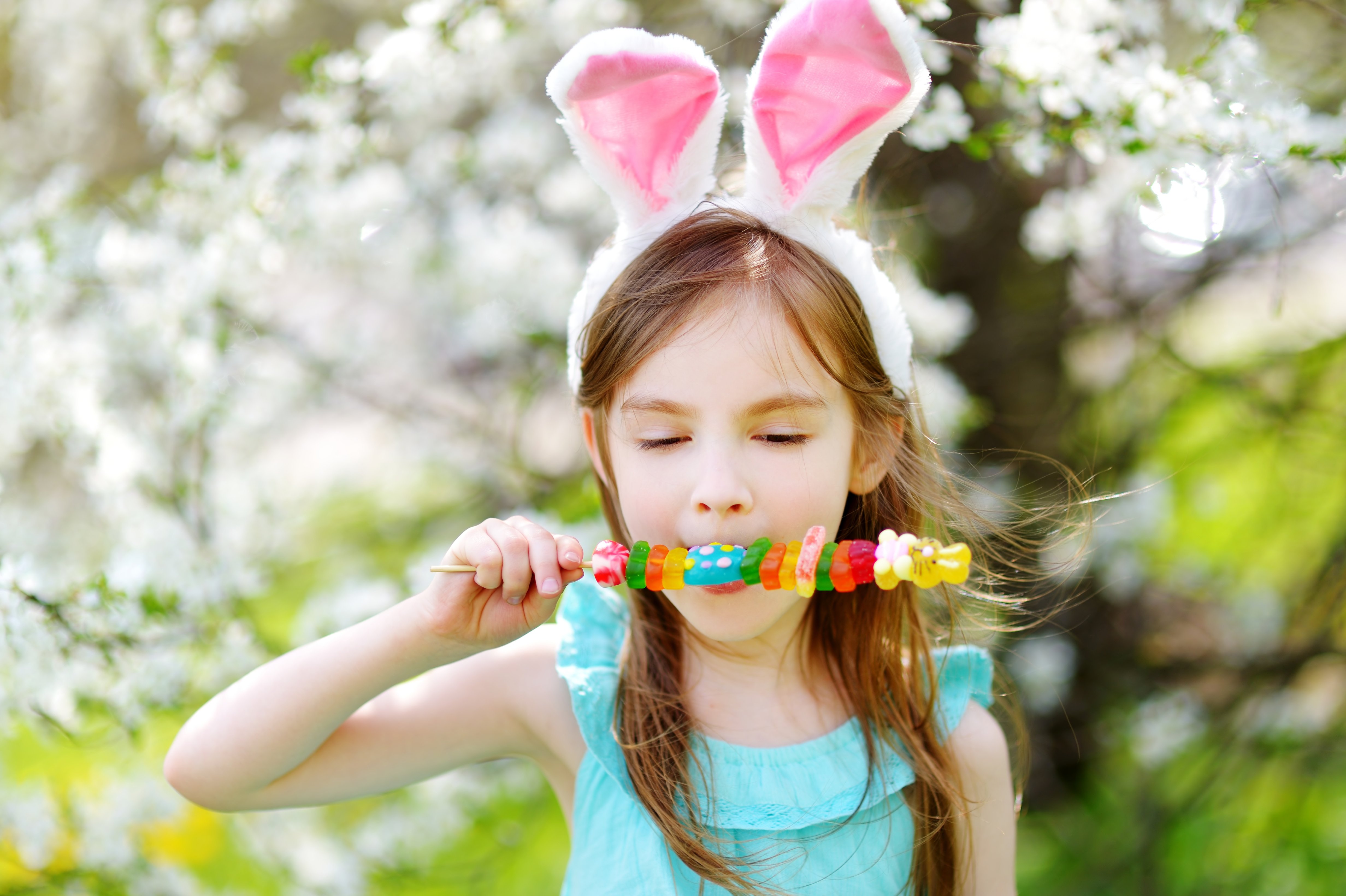 girl-wearing-bunny-ears-and-eating-easter-candy-rabbit
