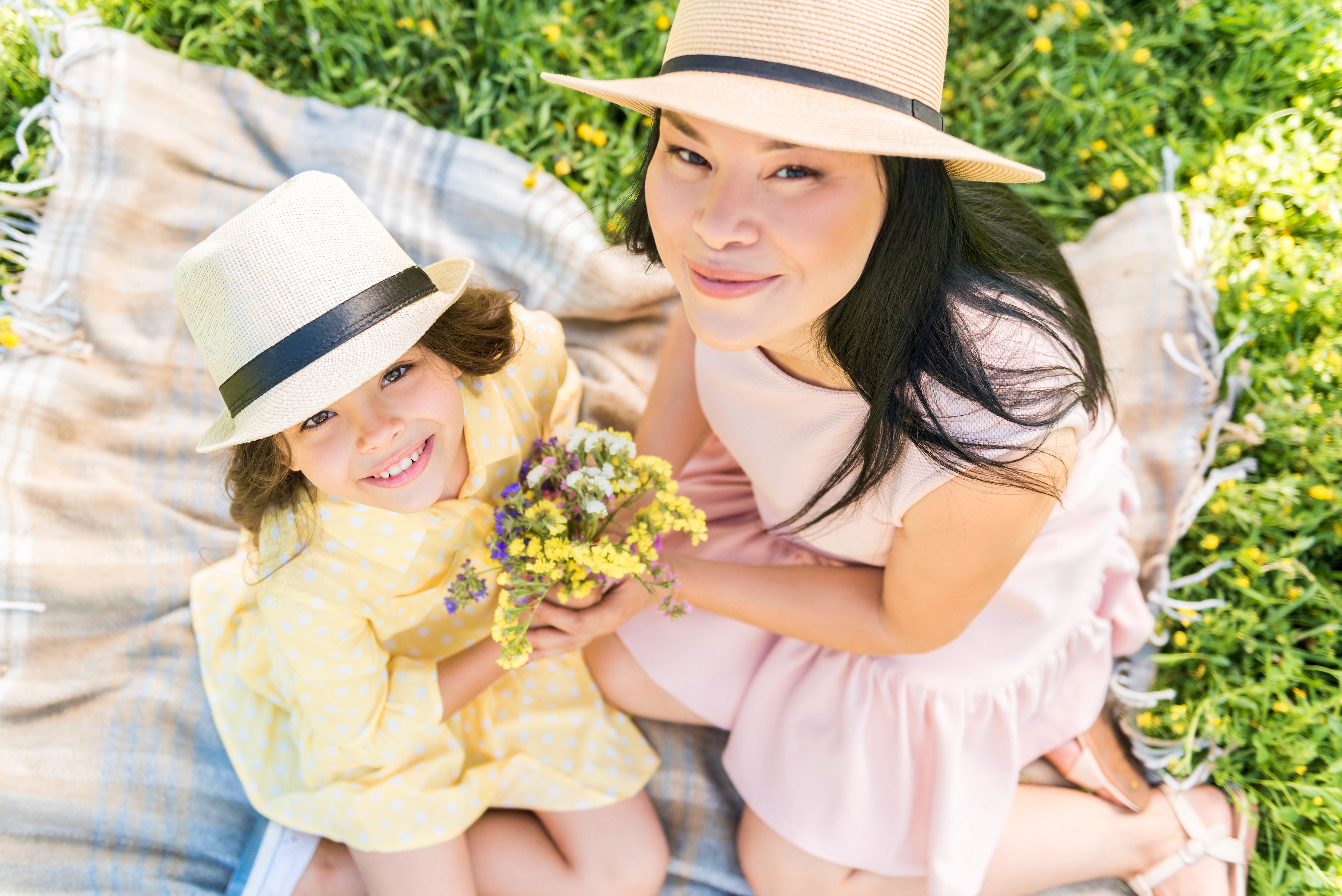 mother and daughter holding flowers outside on a spring day