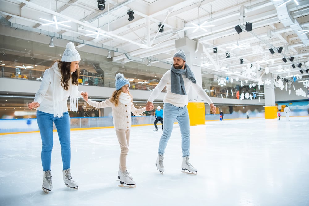 Family ice skating at an indoor rink