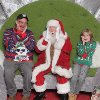 Santa with a father and son making the Home Alone shocked face with their hands on their cheeks.