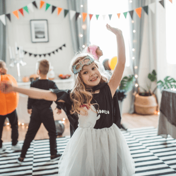 Little girl dancing with streamers in the background.