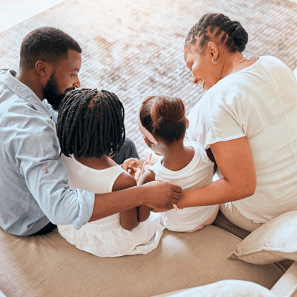 A family gathering together on the couch.