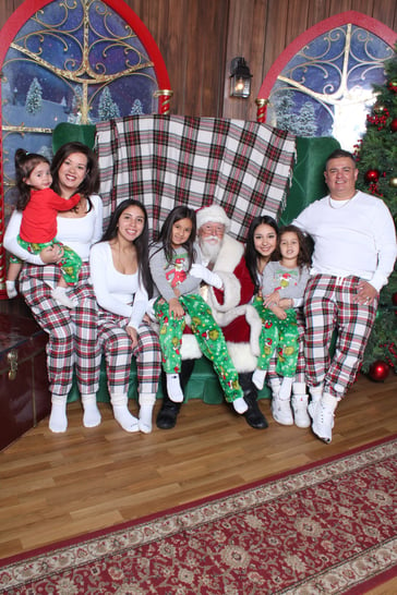 A big family in matching pjs sitting with Santa