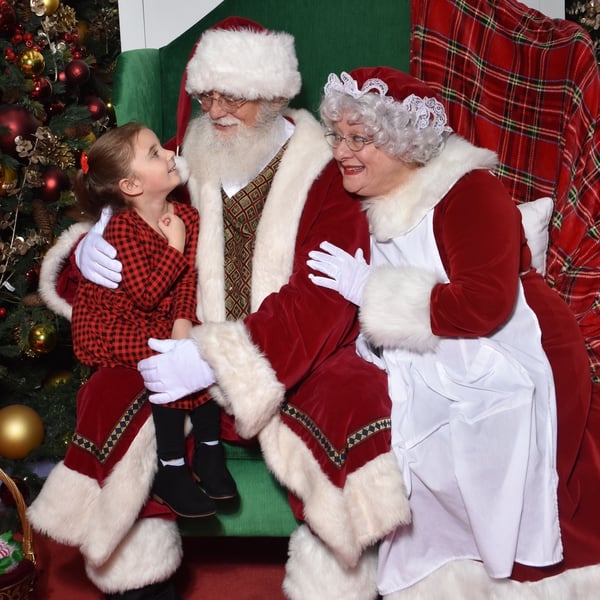 Little girl visiting with Santa and Mrs. Claus at the mall's sensory friendly event