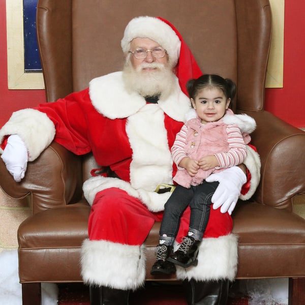 Little girl sitting on Santa's lap