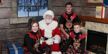 Three children in matching pajamas visiting with Santa at the Reagan Library and Museum