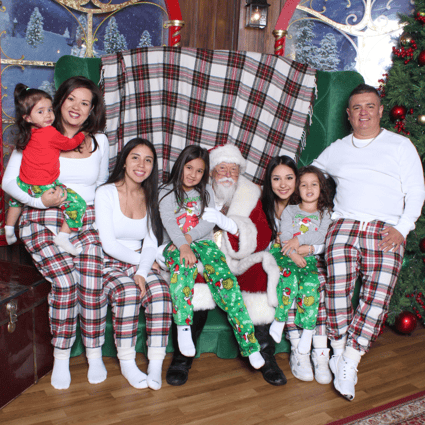 Large family in matching plaid pjs with Santa
