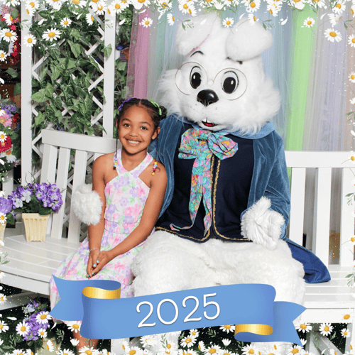 Young girl wearing a pastel dress and posting with the Easter Bunny