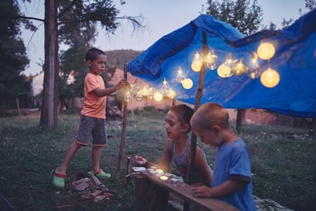 children play at night under a tent