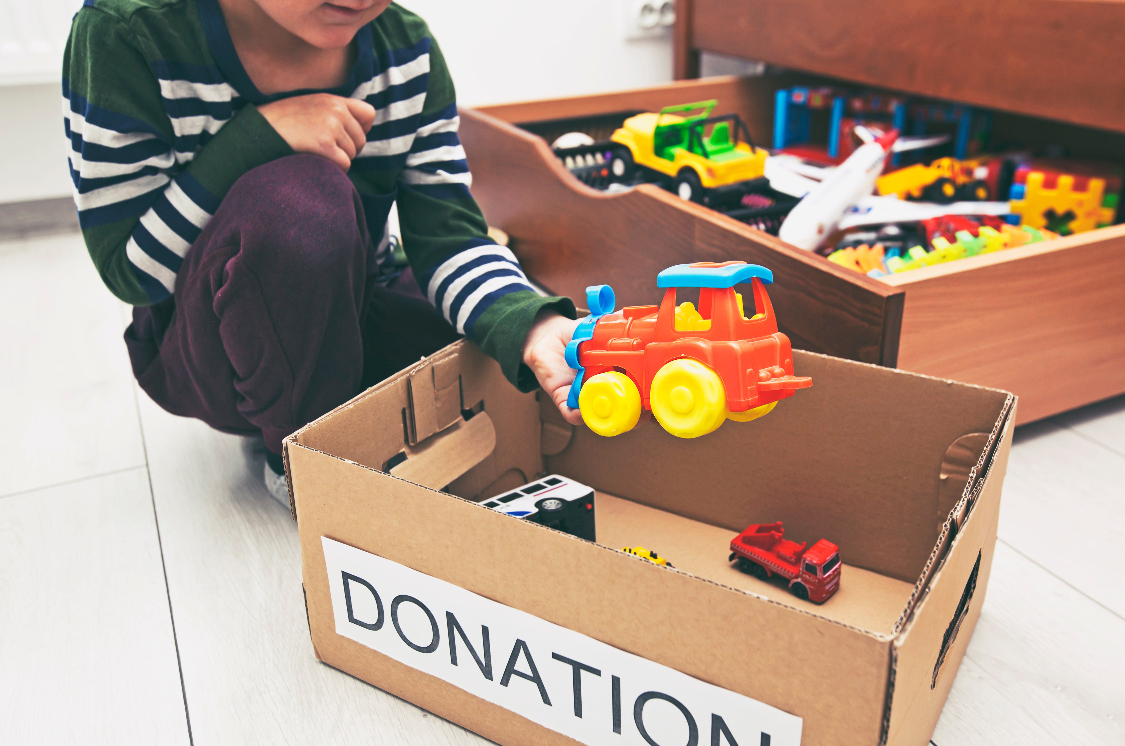 donations-boy-sorting-toys-old-toys-to-donate-donating