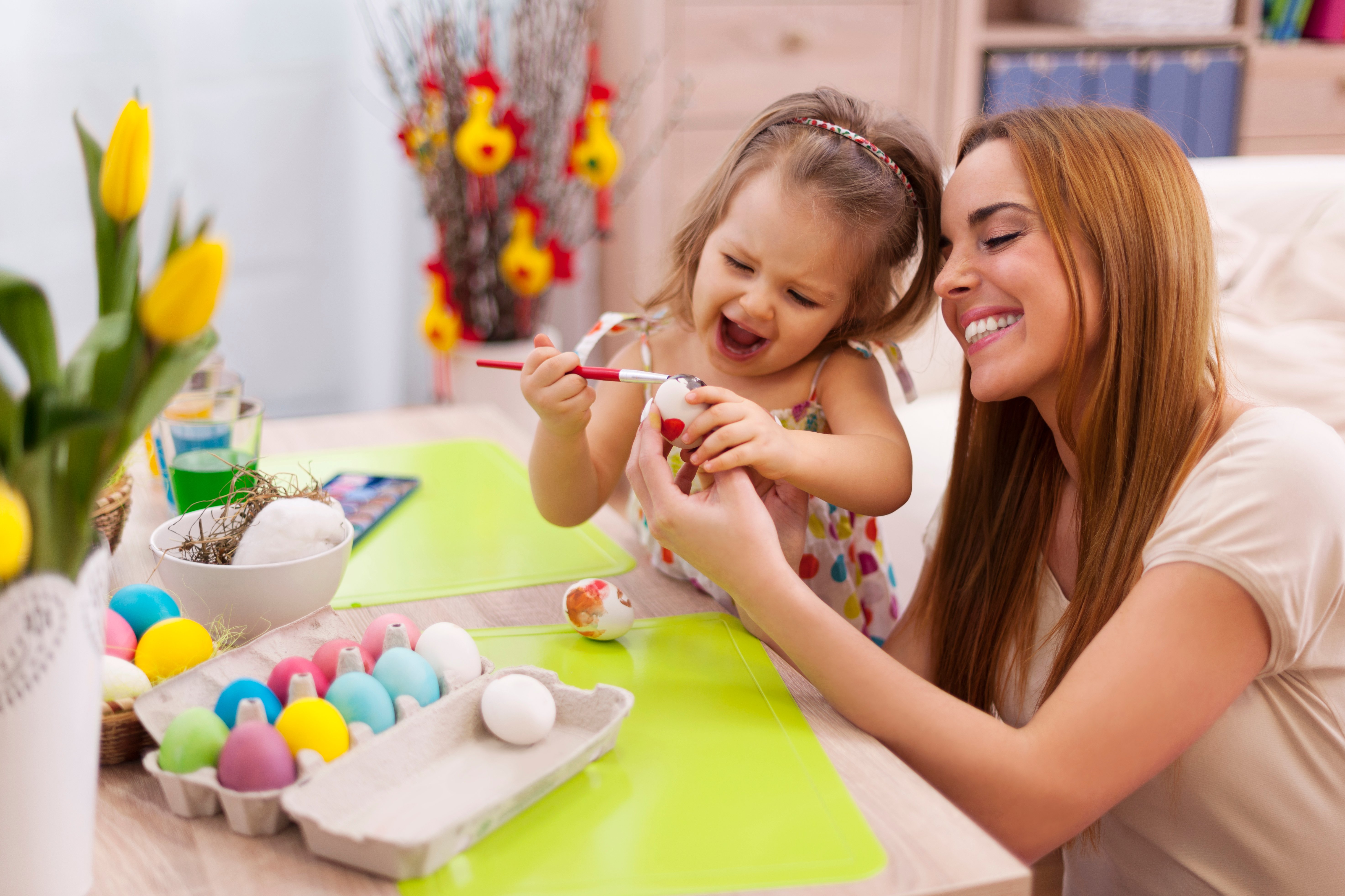 mother and daughter painting easter eggs as a springtime family activity